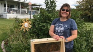 AMA member Terri Vaughn in front of house with beehive