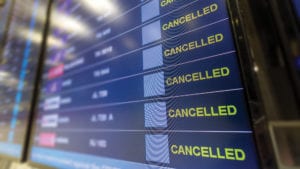 blue airport departure screen showing many cancelled flights