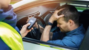 Man stopped in car grimacing because he's run afoul of impaired driving laws