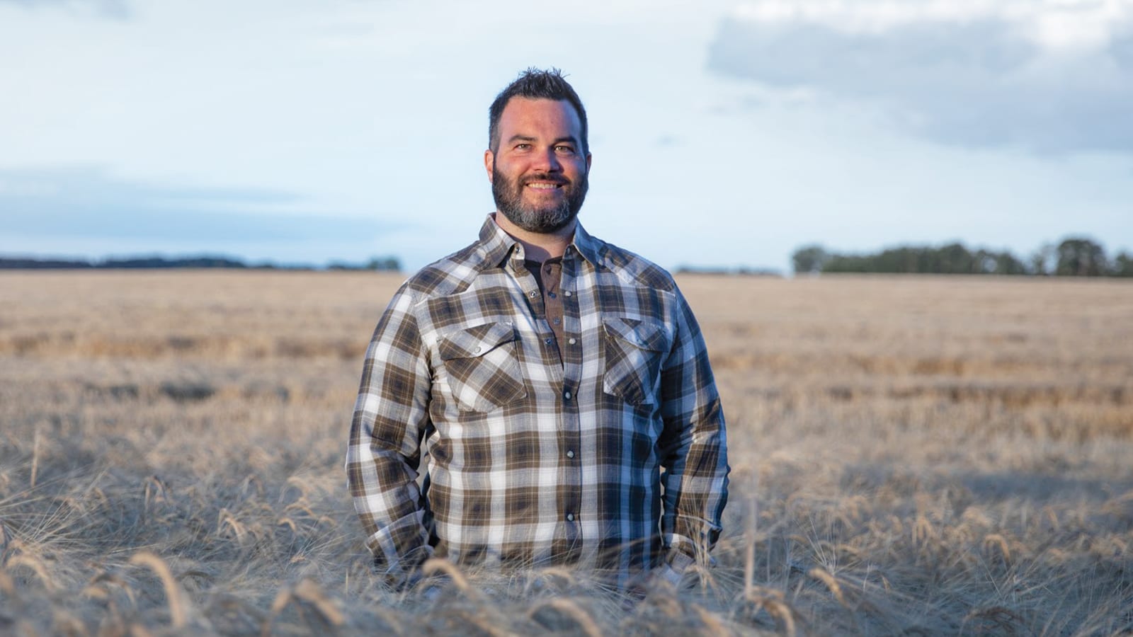Bearded man standing in wheat field