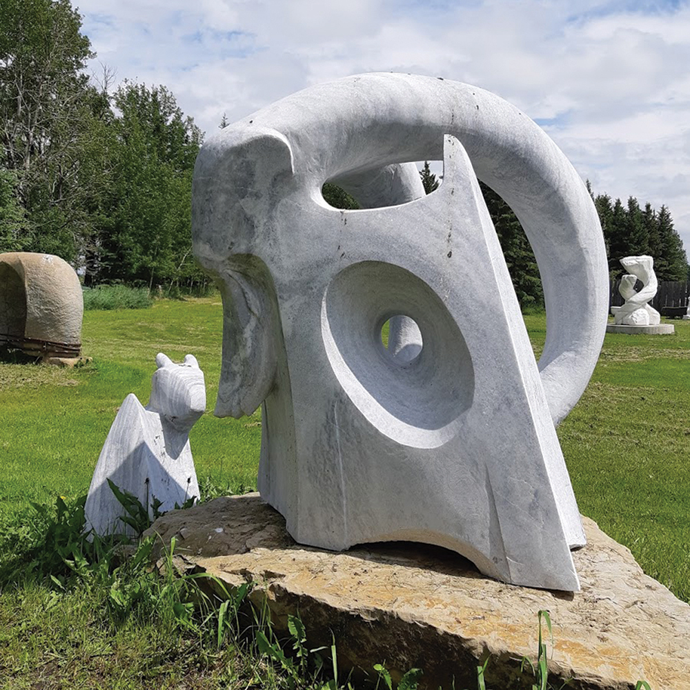 white rock sculpture sitting in field as an example of public art in alberta