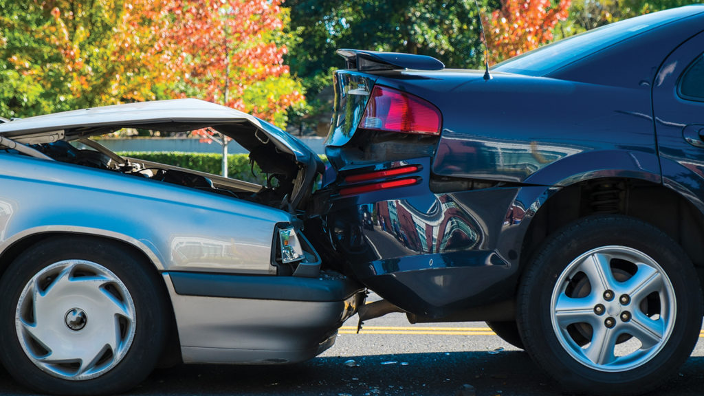 side view of a rear-end collision between silver and dark-blue sedans