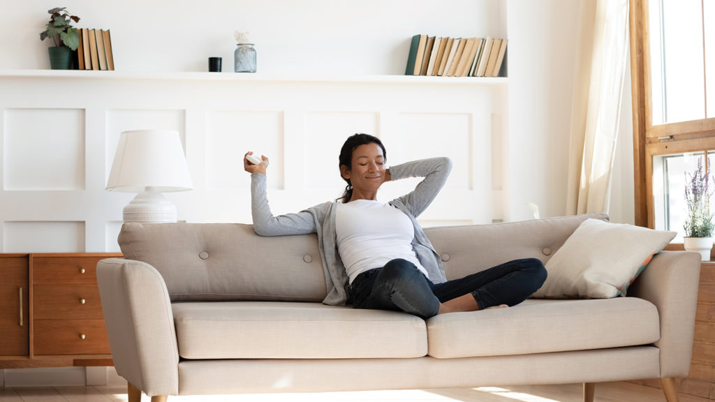 Black woman sitting on couch in contemporary first alberta home