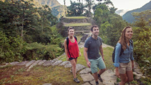 Small group travel as young people walk through ancient South American ruins