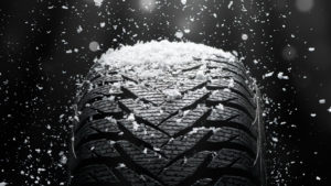 Snow falling on tire tread to illustrate the importance of making the switch to winter tires